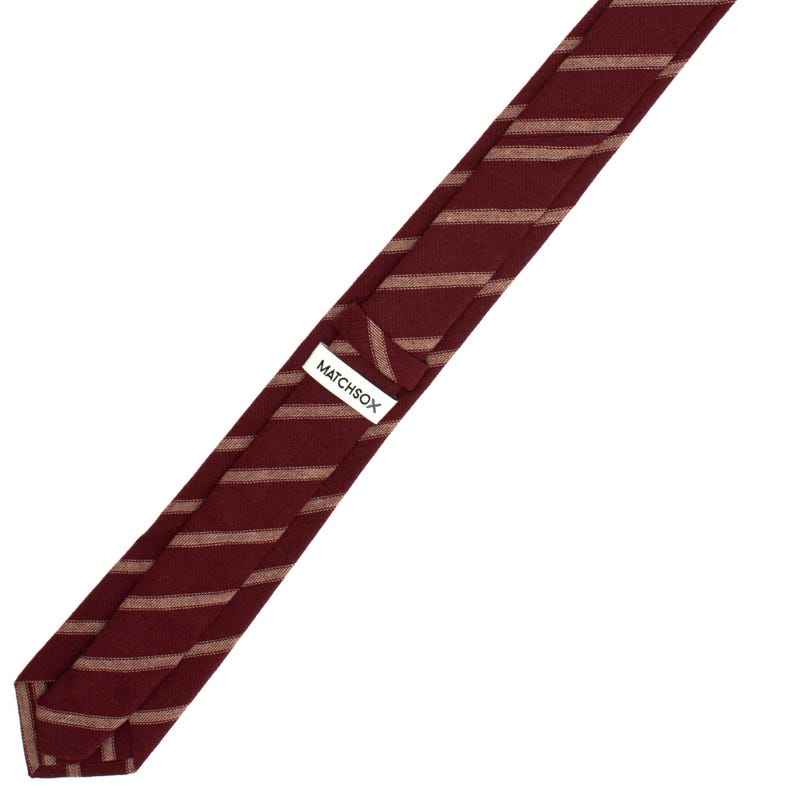 May include: A burgundy and beige striped tie with a white label that says "MATCHSOX".