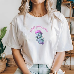 Peut inclure: T-shirt blanc avec un personnage de dessin animé portant une crête rose et le texte "gaslight gatekeep girlboss" en rose.