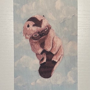 Puede incluir: Una pintura de acuarela de una criatura peluda marrón y blanca con una franja marrón en la cabeza. La criatura está de pie sobre una nube en un cielo azul.