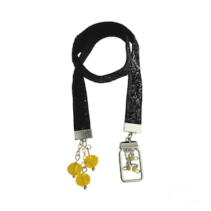 May include: Black glitter bookmark with a silver charm shaped like a mason jar with yellow glass beads. The bookmark has three yellow glass beads dangling from it.