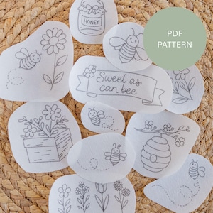 May include: A selection of white fabric patches with embroidered bee and floral designs. Some patches feature the text "Sweet as can bee" and a honey jar. A green circle with the text "PDF PATTERN" is also visible.