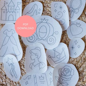 May include: A collection of white fabric patches with gray embroidered designs, including a castle, a dress, a shoe, a carriage, a princess, a crown, a rose, and a magic wand. The text "PDF DOWNLOAD" is in a pink circle.