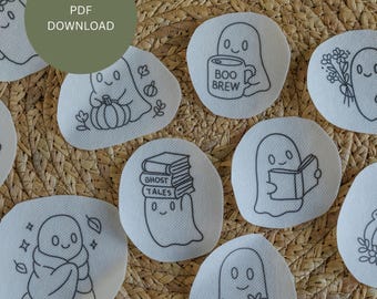 Könnte beinhalten: Eine Sammlung weißer, runder Aufnäher mit schwarzen, gestickten Geistermotiven. Einige Geister halten Kürbisse, Bücher, Blumen oder Tassen mit dem Text "BOO BREW". Ein grüner Kreis mit "PDF DOWNLOAD" befindet sich oben links.