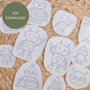 May include: A selection of white fabric patches, each with a different robot design, all outlined in grey stitching. The robots have varied features, including hearts and antennae. A green circle with "PDF DOWNLOAD" is in the top left corner.