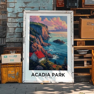May include: A vintage-style poster with a scenic view of a rocky coastline with a small house and trees. The poster is framed in white and has the text "Acadia Park Maine" at the bottom.