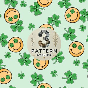 May include: A repeating pattern of smiling faces with shamrock eyes and green shamrocks on a pale green backdrop. The design includes the text "3 PATTERN ATELIER" in a circular logo.