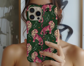 May include: A phone case with a dark green background featuring a repeating pattern of pink and tan tigers, green leaves, and small orange star shapes. The phone case has a camera bump with three lenses.