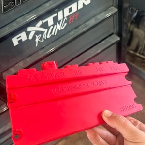 May include: Red plastic connector with the text "TERMINATOR X-MAX" and labels "J4", "PWR", "J3", "J1B", "J1A", and "DUMMY".
