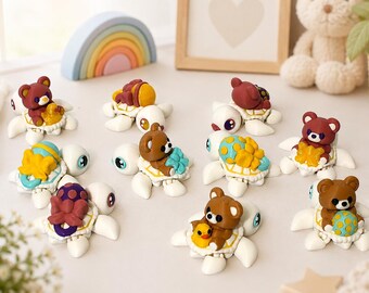 May include: A collection of ten small white turtle figurines, each carrying a different miniature brown bear or colorful object on its shell. The bears are depicted in various poses, some holding items like a yellow duck, a star, or a patterned ball.