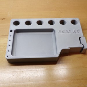 May include: A gray plastic tool organizer with a rectangular tray and multiple round holes. The organizer has the text "AREA 22" printed on the side.