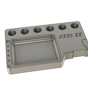 May include: A gray, rectangular organizer with a recessed tray and six circular holes. The text "AREA 22" is printed on the side. The organizer has a stepped design on one corner.