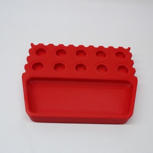 May include: Red plastic organizer with 12 round compartments and a rectangular tray.