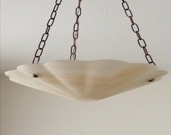 May include: A hanging pendant light fixture featuring a wide, scalloped, off-white glass bowl shade with a smooth, matte finish. The bowl is suspended by three thin, dark metal chains that connect to a central point above the fixture.