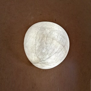 May include: A white, round, textured ceiling light fixture.