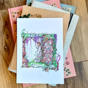 May include: A white print with a colorful illustration of a girl reading a book in a secret garden. The text "Secret Gardens in my Mind" is written in cursive above the illustration.