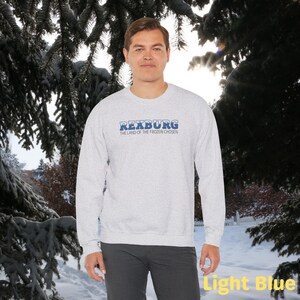 May include: A light gray sweatshirt with a blue graphic that says "Rexburg, The Land of the Frozen Chosen".