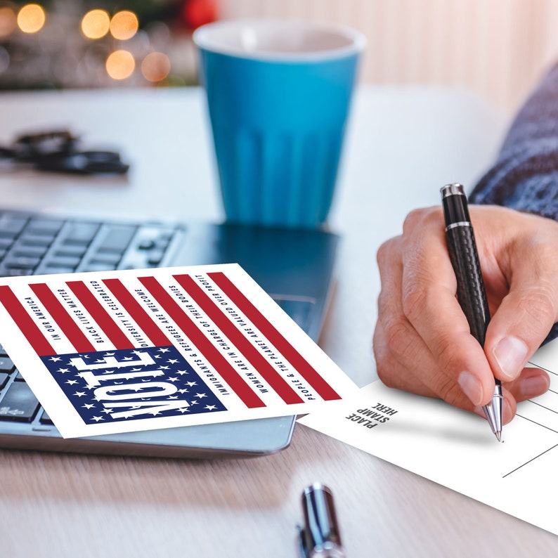 May include: A postcard with a red, white, and blue American flag design. The text on the postcard reads "Vote" in large, bold letters. The text below the flag reads "People & the Planet are valued over profit", "Women are in charge of their bodies", "Immigrants & Refugees are welcome", "Diversity is celebrated", "Black Lives Matter", and "Vote in our America".