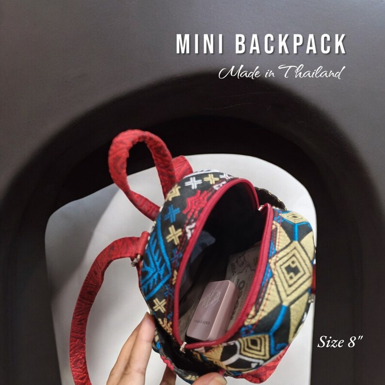 May include: A small, red, black, and gold patterned backpack with adjustable straps. The backpack is 8 inches in size and made in Thailand.  "MINI BACKPACK" and "Made in Thailand" are printed on the image.