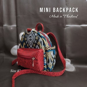 May include: A small red and black patterned backpack with a zippered pocket on the front. The backpack has a long adjustable strap and is labeled "MINI BACKPACK Made in Thailand" and "Size 8".