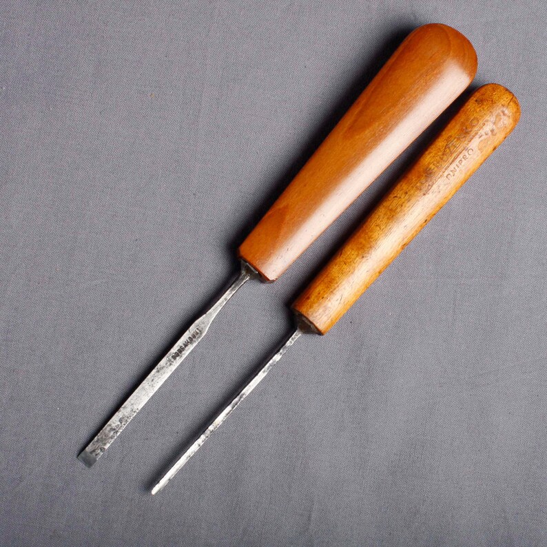 Peut inclure: Deux ciseaux &agrave; bois avec manches en bois. L'un a un manche lisse, brun clair, tandis que l'autre a un aspect plus fonc&eacute; et vieilli. Les lames m&eacute;talliques sont argent&eacute;es et pr&eacute;sentent des signes d'utilisation.