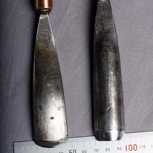 K&ouml;nnte beinhalten: Eine wei&szlig;e Keramiktasse mit schwarzem Henkel und dem Text "But First, Coffee" in schwarzer, fetter Schrift. Die Tasse steht auf einer Holzoberfl&auml;che. Die Tasse ist etwa 10 cm hoch.