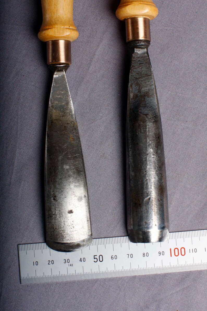 K&ouml;nnte beinhalten: Eine wei&szlig;e Keramiktasse mit schwarzem Henkel und dem Text "But First, Coffee" in schwarzer, fetter Schrift. Die Tasse steht auf einer Holzoberfl&auml;che. Die Tasse ist etwa 10 cm hoch.