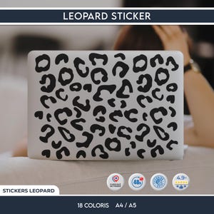 以下が含まれることがあります： 黒いヒョウ柄のステッカーが付いた白いノートパソコン。ステッカーはノートパソコンの表面全体を覆っています。「LEOPARD STICKER」の文字が上部にあります。追加テキスト：「STICKERS LEOPARD」、「18 COLORIS」、「A4 / A5」。
