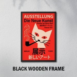 May include: A red and white poster with a black frame. The poster features a cartoon cat smoking a pipe with the text "AUSSTELLUNG Die Neue Kunst" and "K&uuml;nstler der Neuen Welt" in German. The text "新世界のアーティスト" in Japanese translates to "Artists of the New World". The poster also includes the text "Februar 1977", "BERLIN", "TOKIO", "展示", and "新しいアート" in Japanese, which translates to "New Art".