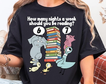 Puede incluir: Camiseta negra con el texto "How many nights a week should you be reading?" e ilustraciones de animales de dibujos animados. El diseño incluye una pila de libros y los números 6 y 7. Tema lúdico y educativo.