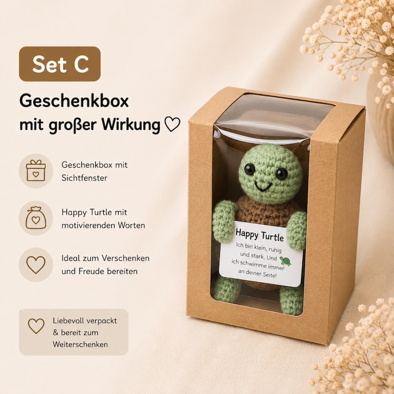 May include: A crocheted green turtle with a brown shell is displayed in a clear-windowed cardboard gift box. The turtle holds a card with text. The box is part of a gift set, as indicated by the text "Set C".