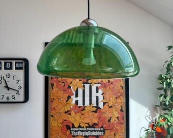 May include: A dome-shaped pendant light fixture featuring a translucent green ribbed glass shade with a chrome-finished top mount and a black cord. The light hangs suspended in front of a framed poster for the film Air The Virgin Suicides.