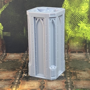 May include: A gray, detailed, plastic model of a gothic tower with a square base and pointed arches. The tower is about 10 inches tall.