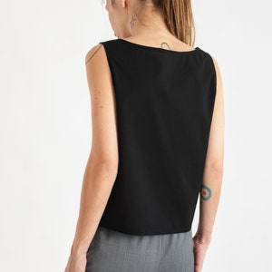 May include: A black sleeveless top with a scoop neck. The top is made of a soft, lightweight fabric and has a relaxed fit.