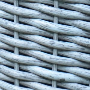 May include: Close-up of a woven material with a light gray color. The weave pattern is tight and consistent, with horizontal and vertical strands creating a textured surface. The material appears to be made of a durable, weather-resistant material.