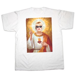 May include: White t-shirt with a graphic print of a woman wearing sunglasses and a halo, holding a cigarette and a heart with a cross on it.