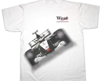 May include: White t-shirt with a black and white image of a race car and the text "West F1 Grand Prix Racing Team" printed on the front.