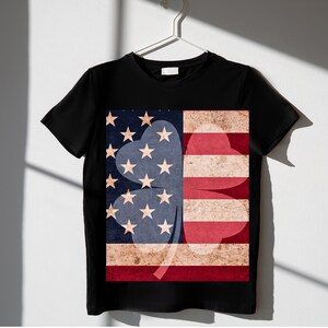 May include: Black t-shirt with a four-leaf clover design made from the American flag. The clover is red, white, and blue.