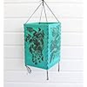 Pode incluir: Llanterna de papel azul turquesa com um design floral recortado. A lanterna está pendurada em um cordão.