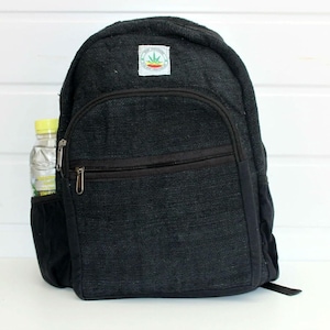 May include: A black hemp backpack with a small green leaf logo on the front. The backpack has a zipped pocket on the front and a side pocket with a water bottle inside.