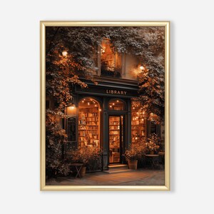 May include: A framed print of a library exterior at dusk. The building has a black facade with the word "LIBRARY" above the entrance. The interior is lit, showcasing bookshelves. Warm lighting and foliage frame the entrance, creating a cozy atmosphere.
