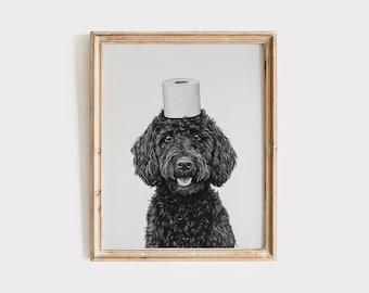 May include: A framed black and white print of a black dog with a roll of toilet paper balanced on its head. The dog has a happy expression, with its tongue slightly visible. The print is in a wooden frame.