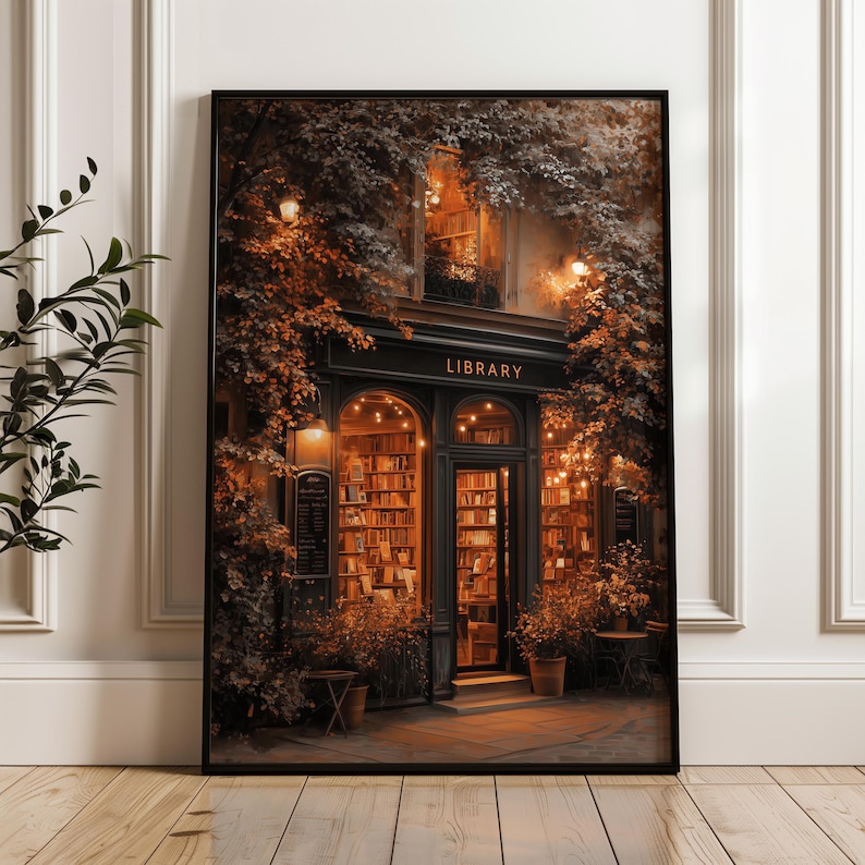 May include: A framed print of a quaint library facade, with the word "LIBRARY" above the entrance. The building is adorned with climbing plants and warm lighting, suggesting a cozy atmosphere. Bookshelves are visible through the arched doorway and windows.