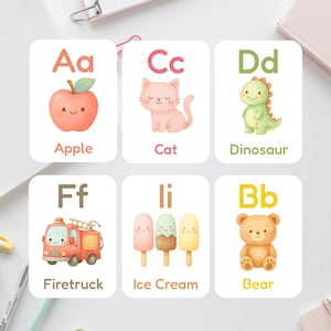 Puede incluir: Juego de seis tarjetas didácticas con ilustraciones en acuarela de una manzana, un gato, un dinosaurio, un camión de bomberos, helados y un oso. Cada tarjeta muestra una letra y una palabra, como "Aa Apple" y "Bb Bear".