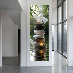 May include: A vertical canvas print showing a stack of smooth, grey and white stones with a lit candle at the base and top. White orchids and bamboo leaves are in the background, with a rippled water effect.