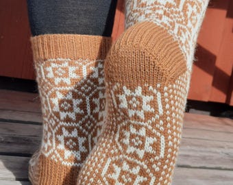 Peut inclure: Paire de chaussettes tricotées marron et blanches avec un motif géométrique. Les chaussettes sont visibles des chevilles vers le bas. Fabriquées dans une matière douce et chaude, idéales pour les temps froids.