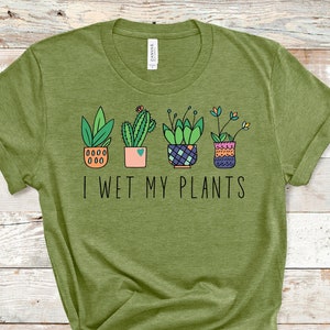 May include: Green t-shirt with a graphic of potted plants and the text "I wet my plants".