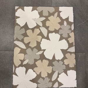 May include: A rectangular canvas featuring a floral pattern. The flowers are painted in white, beige, and gray, set against a brown background. The artwork has a textured appearance, with visible brushstrokes, creating a modern, abstract aesthetic.