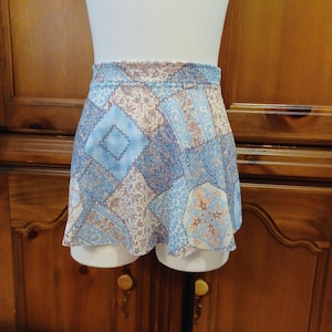 May include: A blue and white patterned dance skirt with a ruffled hem. The skirt is made of a soft, flowing fabric and has a comfortable elastic waistband.