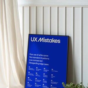 Op de afbeelding: Een blauwe poster met witte tekst die veelvoorkomende UX-fouten opsomt. De poster heeft de titel "UX Mistakes" en somt 20 veelvoorkomende fouten op met nummers en korte beschrijvingen. De poster is zwart ingelijst en leunt tegen een witte muur.