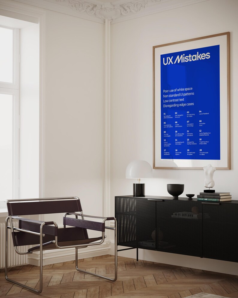 Op de afbeelding: Een blauwe poster met de tekst "UX Mistakes" en een lijst met veelvoorkomende UX-fouten. De poster hangt aan een witte muur in een kamer met een stoel en een bijzettafel.
